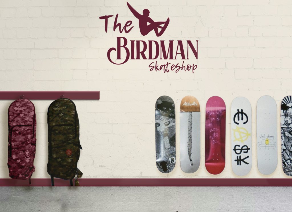 Intérieur du skateshop The Birdman avec planches, housses murales et logo sur le mur – univers visuel de la marque
