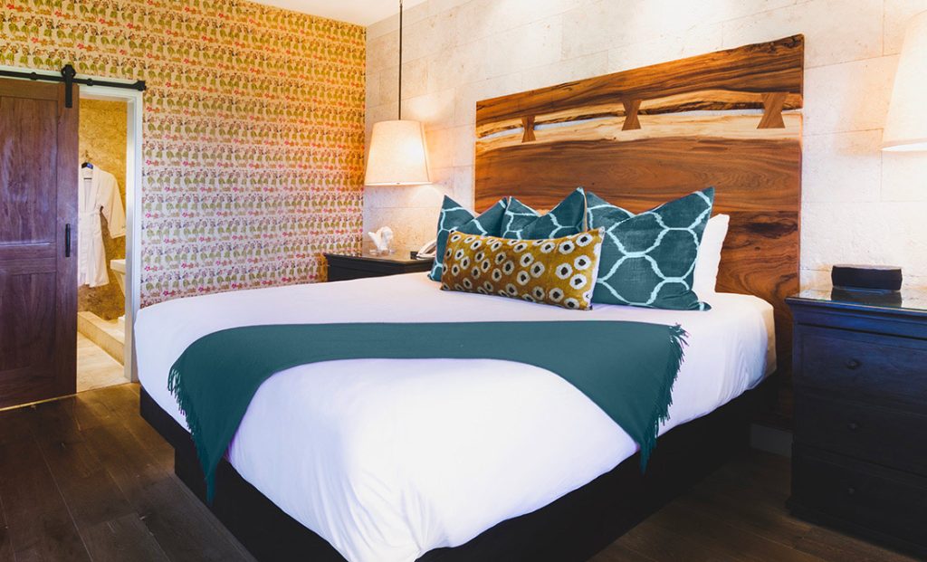 Chambre de l’hôtel Keeahnoo avec couvre-lit aux couleurs de l’identité visuelle