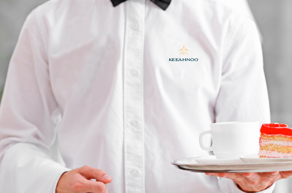 Serveur portant une chemise avec le logo brodé Keeahnoo – uniformes personnalisés hôtel de luxe