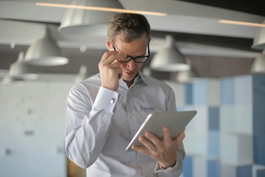 Homme avec une chemise géovignes tenant une tablette
